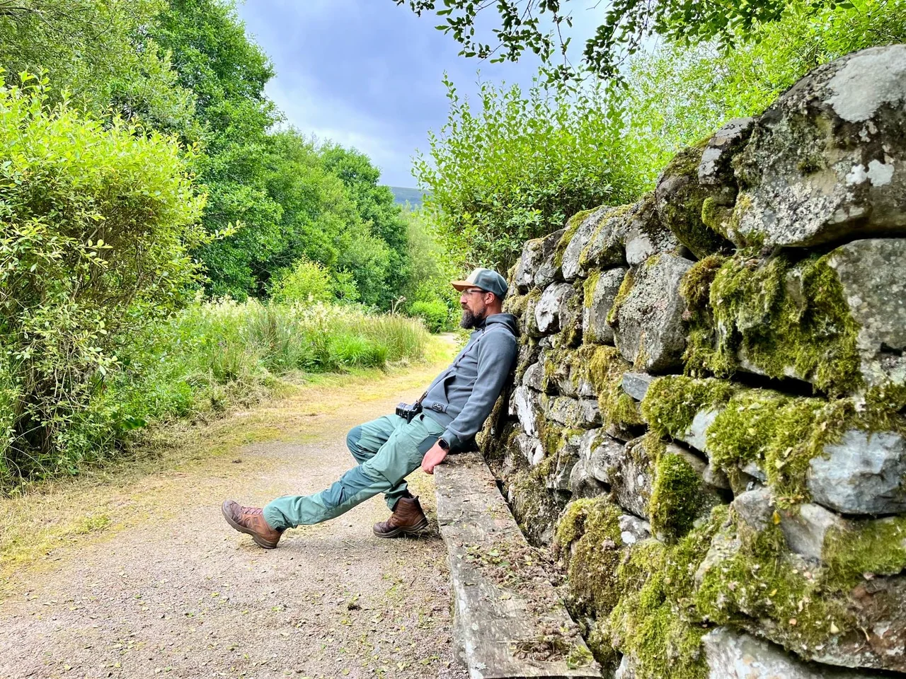 Marc sitzt beim England-Roadtrip draußen an einer alten Steinmauer