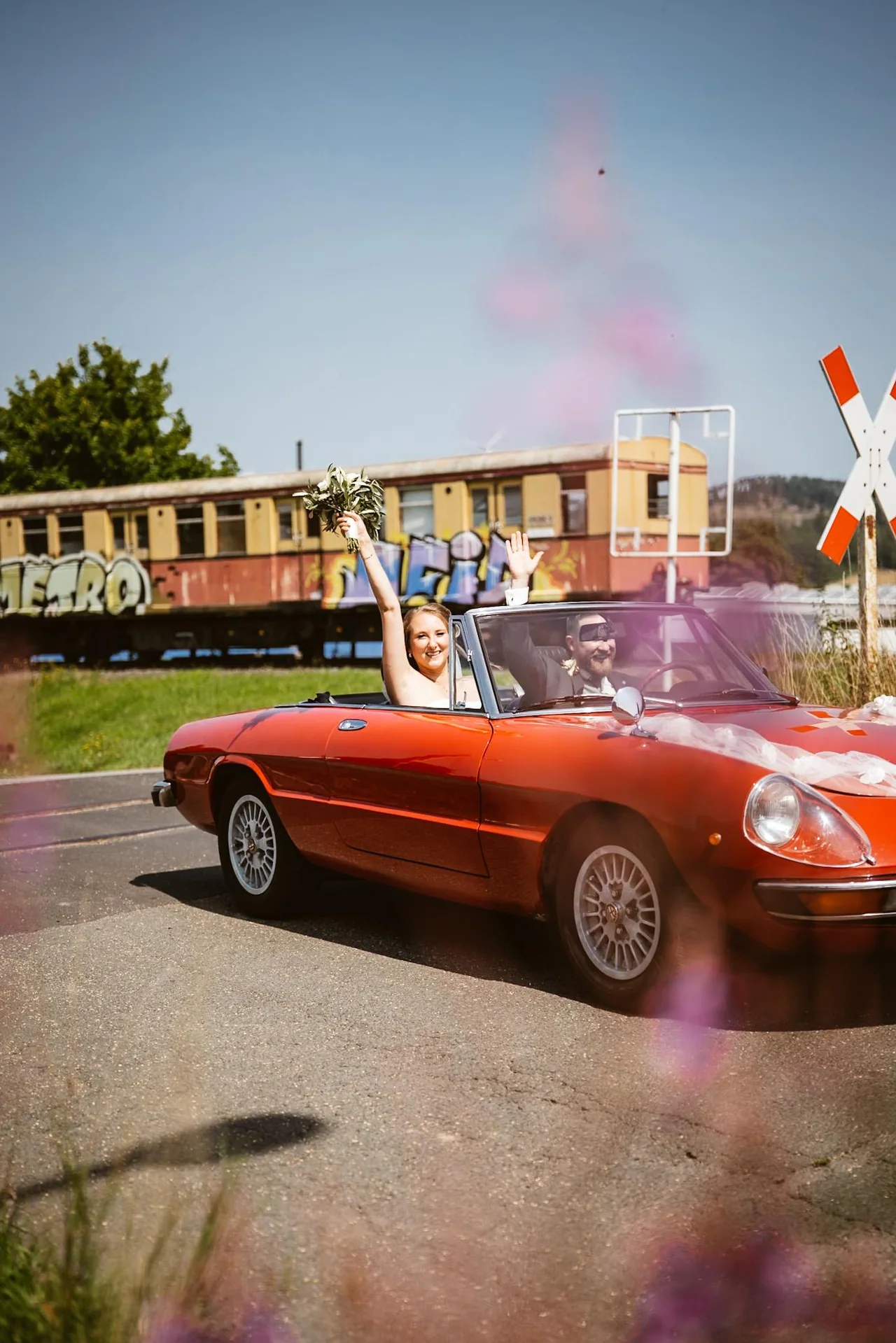Hochzeitspaar fährt mit einem festlich geschmückten Wagen