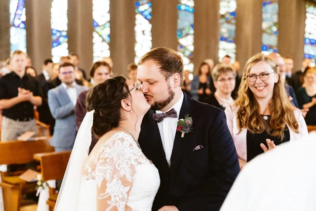 Franzi und Lukas mit lächelnden Gästen bei der Trauung