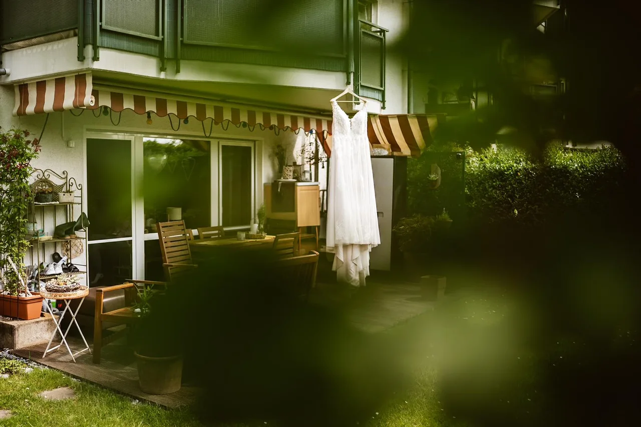 Das Brautkleid hängt am frühen Morgen draußen am Haus