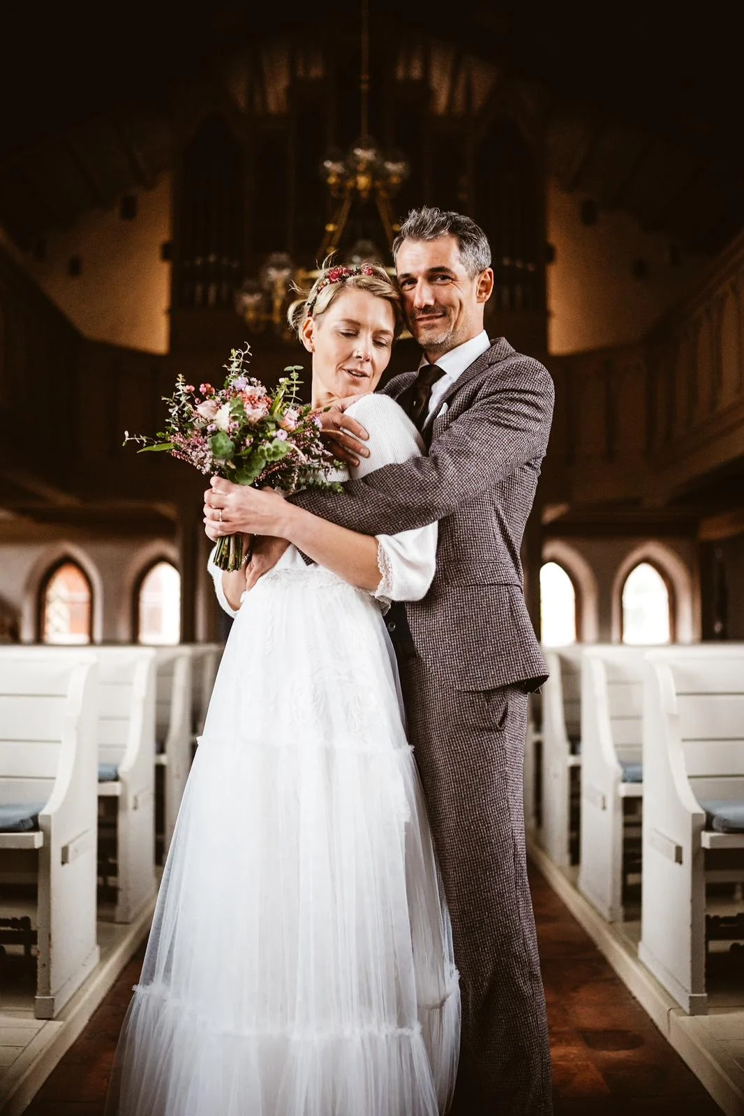 Mella und Christoph stehen nah beieinander in einer kleinen Kirche