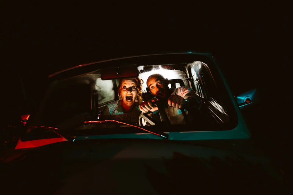 Zwei Menschen lachen nachts gemeinsam im Auto