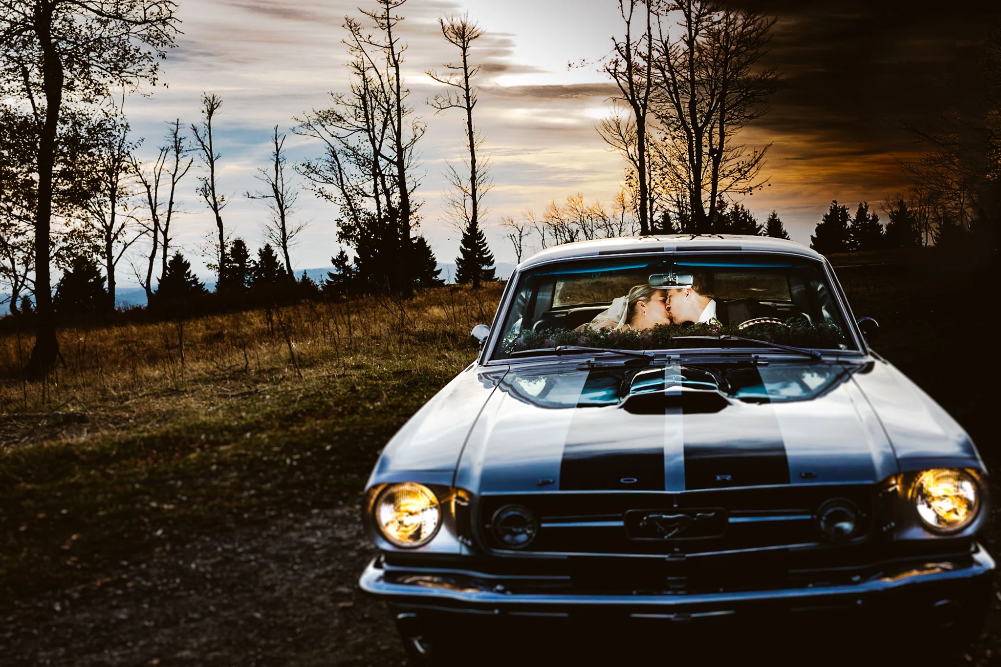 Hochzeitspaar im Oldtimer im Abendlicht