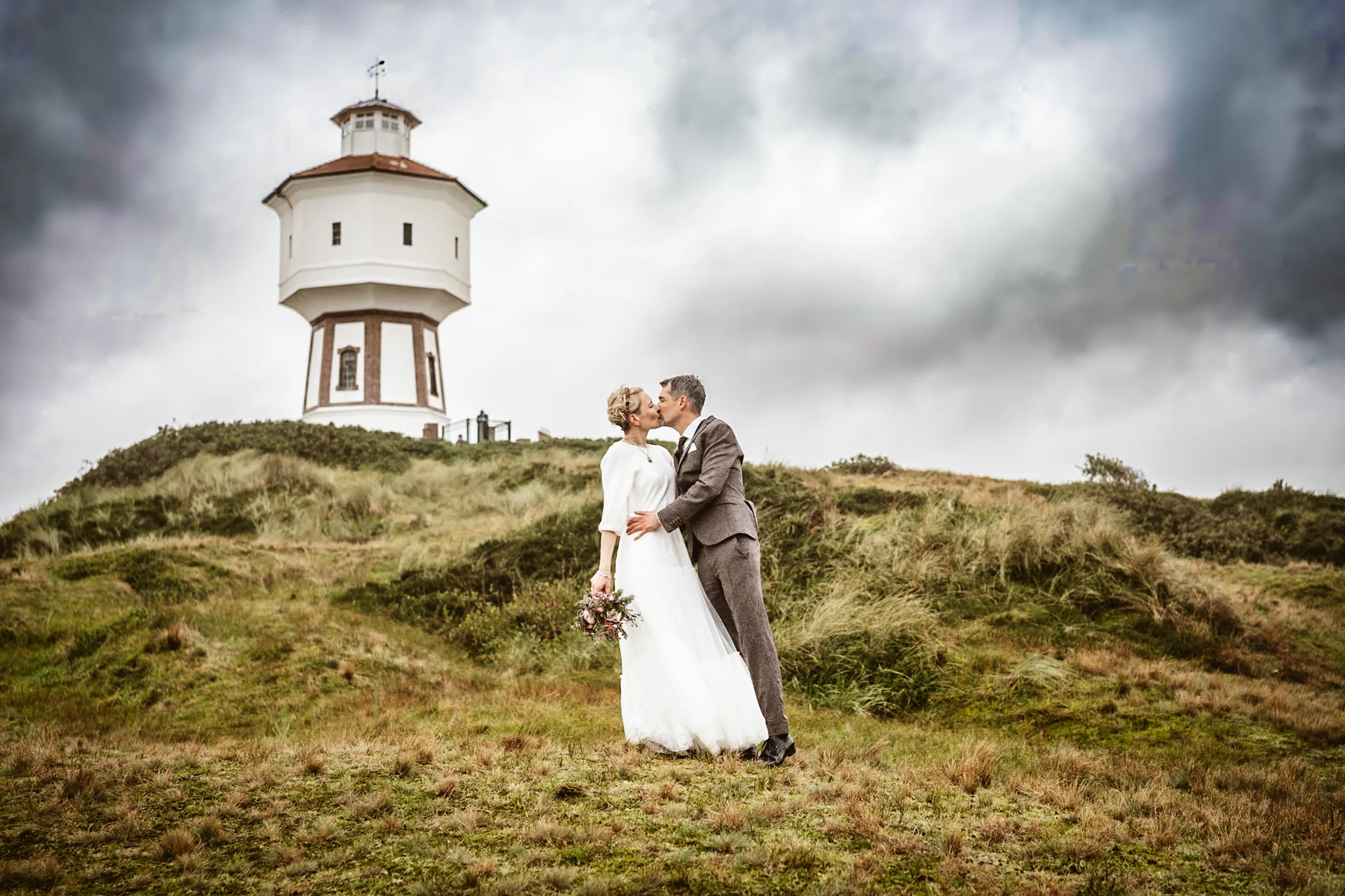 Mella und Christoph unter Wolken vor dem Leuchtturm